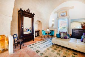 a living room with a couch and a mirror at Suite San Pietro - Sassi di Matera in Matera
