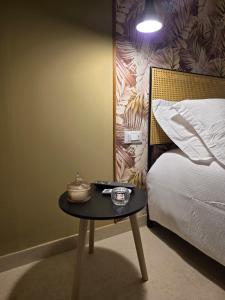 a small table next to a bed in a room at Erbanova al Borgo Suite in Taranto