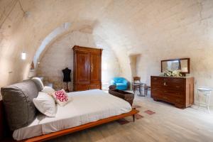 a bedroom with a bed and a dresser in a room at Suite San Pietro - Sassi di Matera in Matera