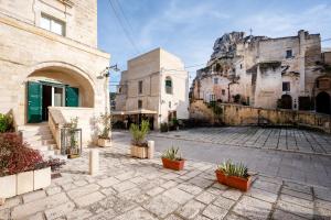 a courtyard in an old building with potted plants at Suite San Pietro - Sassi di Matera in Matera