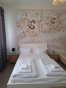 a bedroom with a white bed with flowers on the wall at Elifim in Berlin