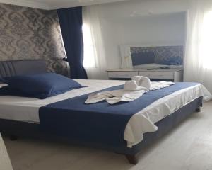 a bedroom with a bed with a stuffed animal on it at erşan hotel in Foça +6 photos