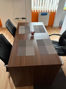 a wooden table with black chairs around it at LUMON Ultra Central Apartman in Târgu-Mureş +11 photos