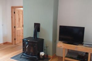 a living room with a flat screen tv and a wooden table at Sleeps6-FamilyFriendly-FreeParking-Garden in Ballybunion +19 photos