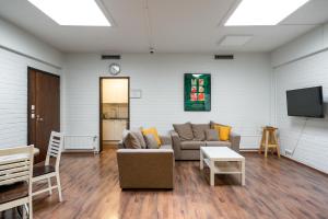 a living room with a couch and a tv at Hiisi Hostel Vihti - Private Rooms in Vihti