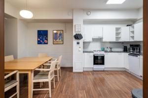 a kitchen with a wooden table and white cabinets at Hiisi Hostel Vihti - Private Rooms in Vihti