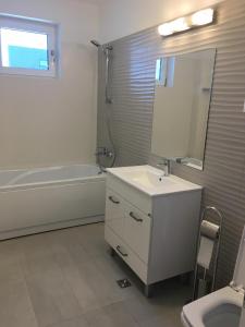 a bathroom with a sink and a tub and a mirror at Two rooms Vivo Metro Amethyst in Floreşti