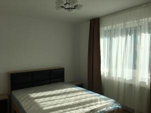 a bedroom with a bed and a window at Two rooms Vivo Metro Amethyst in Floreşti