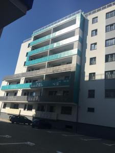 a tall building with cars parked in front of it at Two rooms Vivo Metro Amethyst in Floreşti