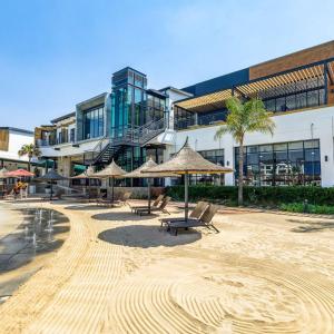 a building with benches and umbrellas in front of it at The blyde-Luxury one bedroom apartment in Pretoria