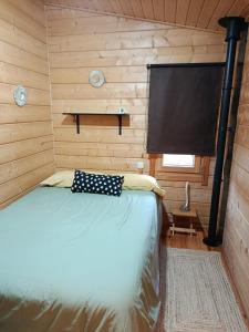 a bedroom with a bed in a wooden cabin at La casita de Rascafria in Rascafría