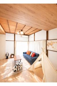 a living room with a blue couch and a table at Macchiato SHONAN - 綺麗な古民家一棟貸切-海まで5分-無料駐車場-自転車2台-独立乾燥機-お子様大歓迎 Private Traditional House Near Kamakura Hakone, Family-Friendly Stay in Hiratsuka