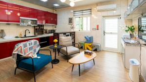 a kitchen with red cabinets and chairs and a table at Kinmen Harved B&B in Jinhu