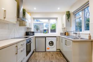a white kitchen with a washer and dryer in it at Gloucester 5 Bedroom Cosy Home-Work or Leisure in Gloucestershire