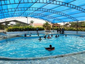 a group of people swimming in a swimming pool at Tejas Gir Villas in Sasan Gir