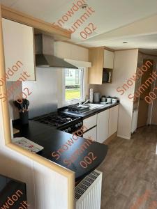 a kitchen with a stove and a counter top at Snowdon Summit 002 in Barmouth