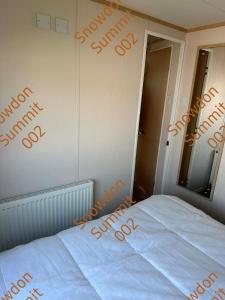 a bedroom with a bed with the word saturday written on the wall at Snowdon Summit 002 in Barmouth +3 photos