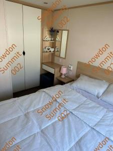 a bedroom with a bed with orange writing on it at Snowdon Summit 002 in Barmouth