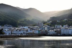 a town next to a body of water with buildings at Winahost Ático Viveiro in Viveiro