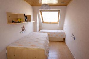 a small room with two beds and a window at Winahost Ático Viveiro in Viveiro