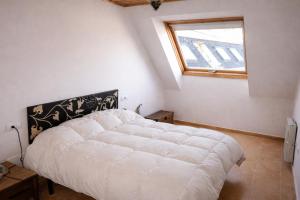a white bed in a room with a window at Winahost Ático Viveiro in Viveiro