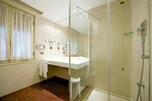 a bathroom with a shower, sink, and tub at Mercure Parma Stendhal in Parma