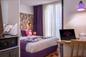 a hotel room with a bed and a laptop on a desk at H&ocirc;tel Villa Boh&egrave;me in Paris
