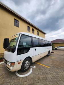 a white bus parked in a parking lot at Lake Naivasha Lazarus Lodge in Naivasha