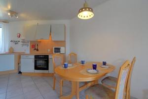 a kitchen with a wooden table with chairs and a dining room at STW24a Bungalow in Dorum-Neufeld