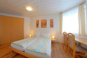 a bedroom with a bed with a desk and chairs at STW24a Bungalow in Dorum-Neufeld