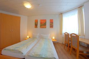 a bedroom with a large bed with two chairs and a desk at STW24a Bungalow in Dorum-Neufeld +9 photos
