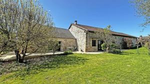 an old stone house with a grass yard at Fayollas in Bussière-Galant