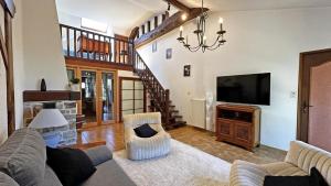 a living room with a couch and a television at Fayollas in Bussière-Galant