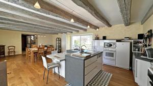 a kitchen with white appliances and a dining room at Fayollas in Bussière-Galant