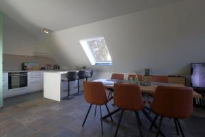 a kitchen with a table and chairs in a room at WK7 "Ferienwohnung Küstenruhe" in Dorum