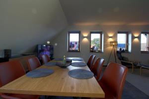a dining room with a wooden table and chairs at WK7 "Ferienwohnung Küstenruhe" in Dorum