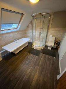 a bathroom with a tub and a glass shower at Station apartment in Llanberis