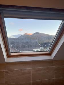 a large window in a room with a mountain view at Station apartment in Llanberis