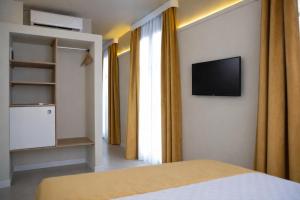 a bedroom with a bed and a television on a wall at Oda Bodrum Gümüşlük in Bodrum City