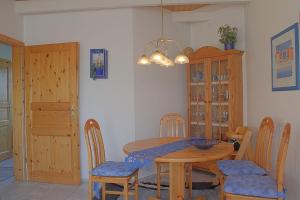 a dining room with a wooden table and chairs at STW45b Bungalow Seestern in Dorum-Neufeld