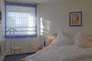 a bedroom with a white bed and a window at STW45b Bungalow Seestern in Dorum-Neufeld +3 photos