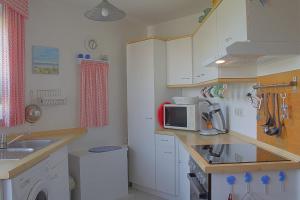 a small kitchen with a sink and a microwave at STW45b Bungalow Seestern in Dorum-Neufeld