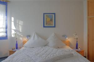 a bed with white sheets and pillows in a bedroom at STW45b Bungalow Seestern in Dorum-Neufeld