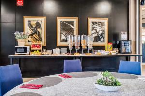 ein Tisch mit blauen Stühlen und eine Theke mit Bildern in der Unterkunft Hotel Ignacio - PalomarGroup in Chiva