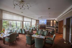 restauracja ze stołami i krzesłami w pokoju w obiekcie Kormoran Medispa w Rowach