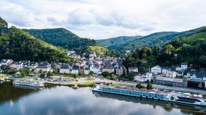 a town on a river with a boat in the water at Residenz Mont Royal in Traben-Trarbach