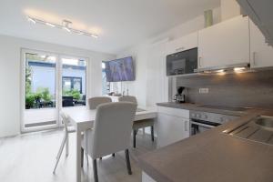 a kitchen with a table and chairs and a kitchen with a counter at KW4 Haus Anna in Dorum-Neufeld