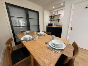a wooden table with plates and utensils on it at The Coach House in Halstead