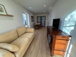 a living room with a couch and a flat screen tv at The Coach House in Halstead +22 photos