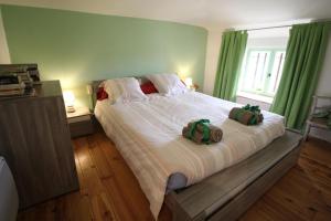 a bedroom with a large bed with two bags on it at Les moissonneurs in Champagnac-la-Rivière